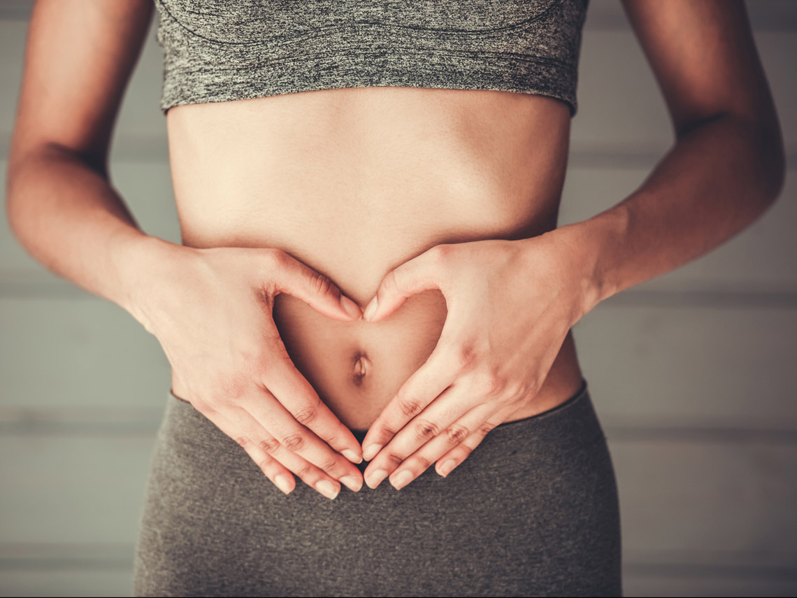 Mujer con manos en el abdomen