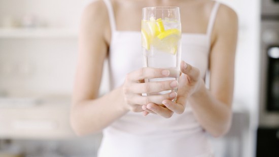 Mujer con un vaso de agua con limón