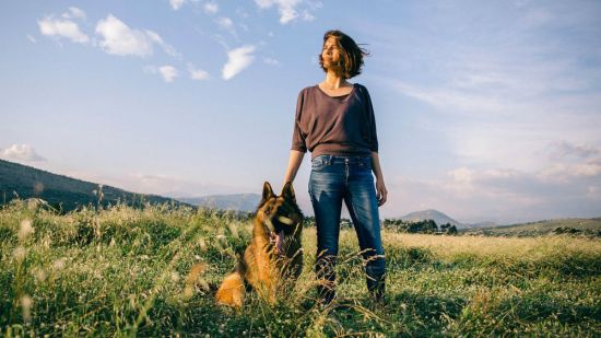 mujer y perro en el campo