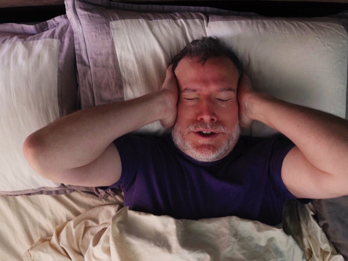 Hombre tapándose los oídos por el ruido excesivo