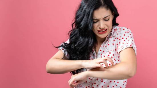 Mujer rascándose el brazo
