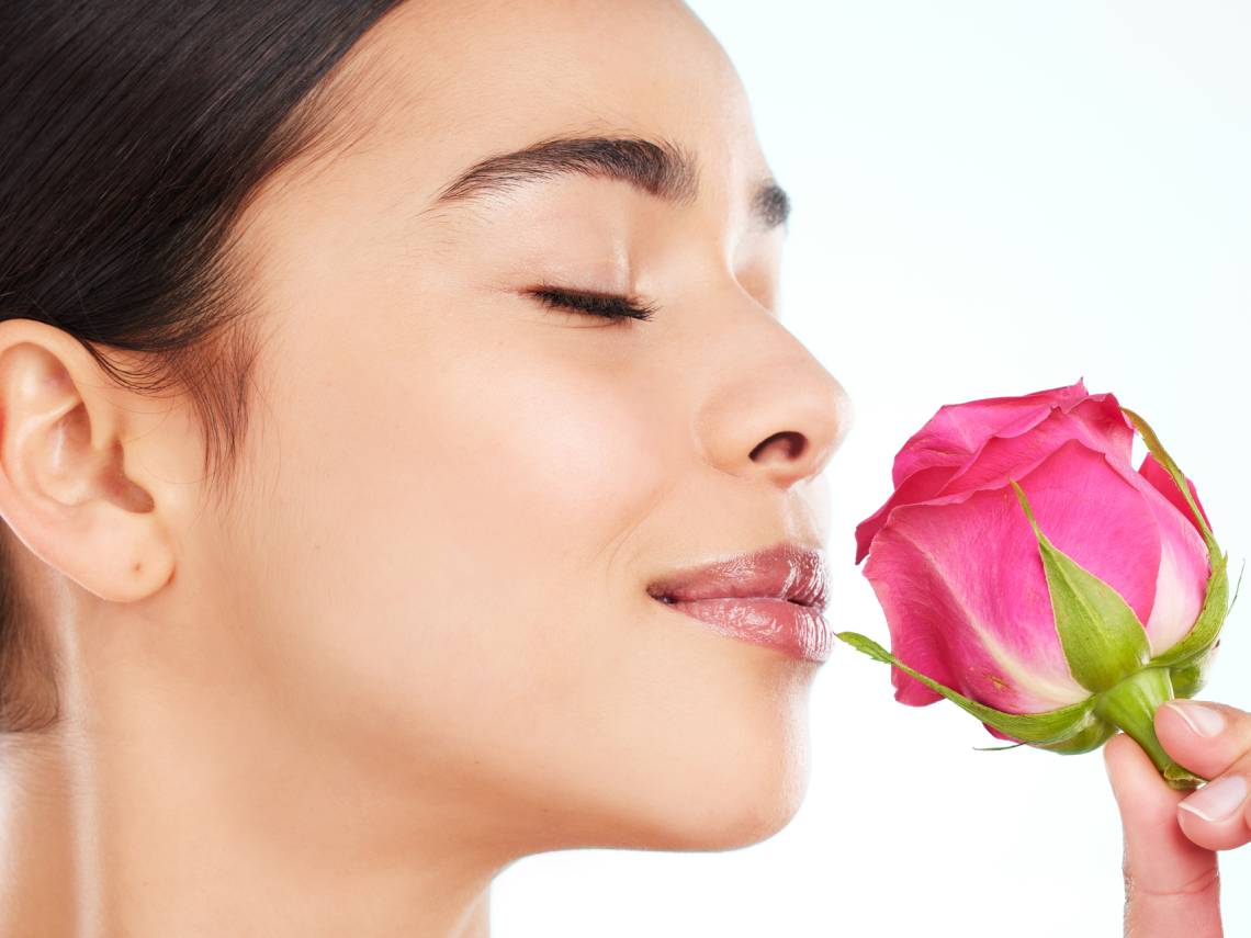 Mujer oliendo una rosa