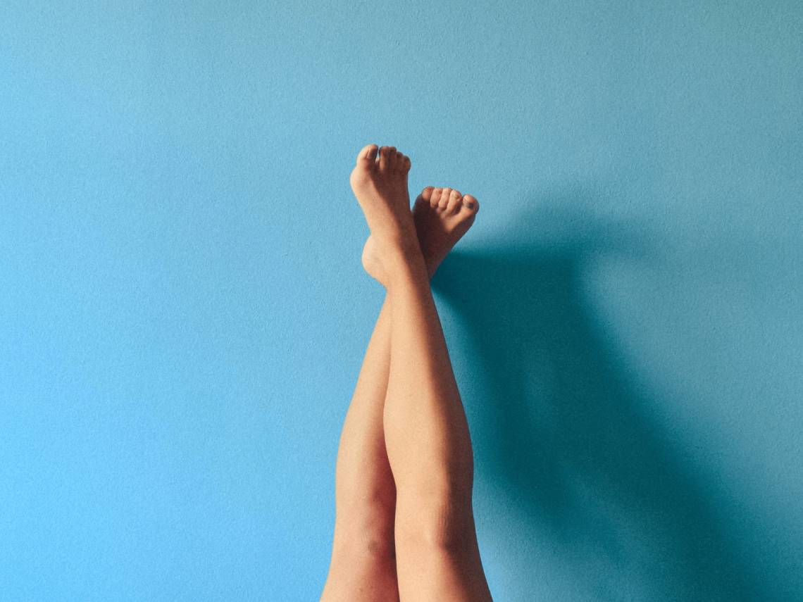 Piernas con varices apoyadas en una pared