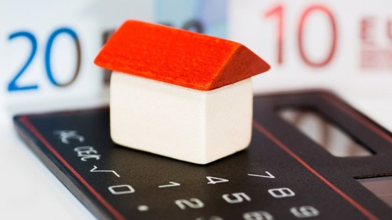 Casa de juguete sobre una calculadora