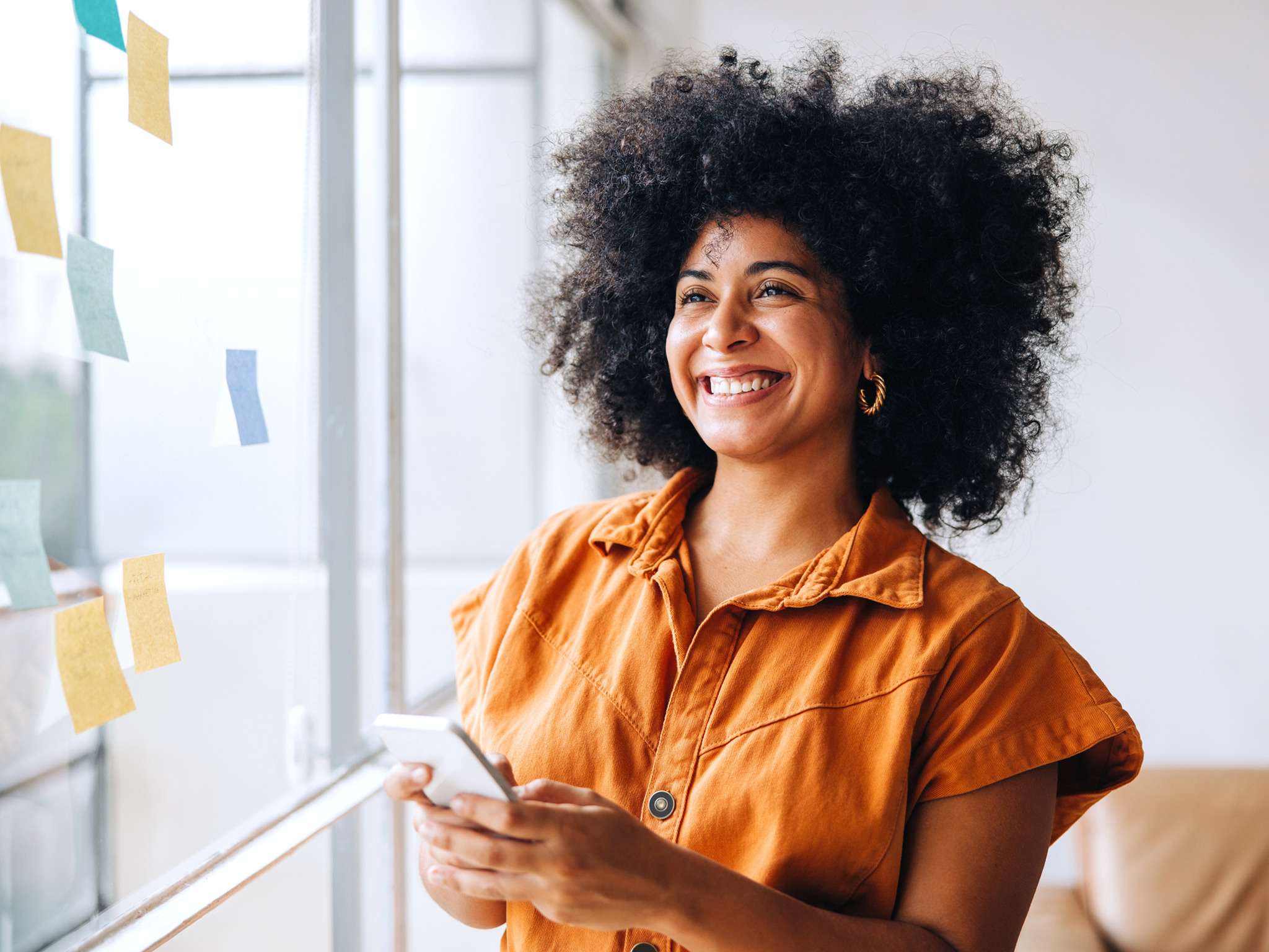 Mujer sonriendo con un móvil en la mano