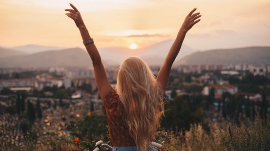 Mujer feliz con los brazos levantados