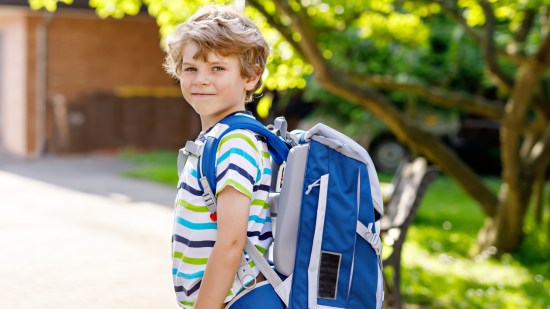 Niño con mochila yendo al colegio