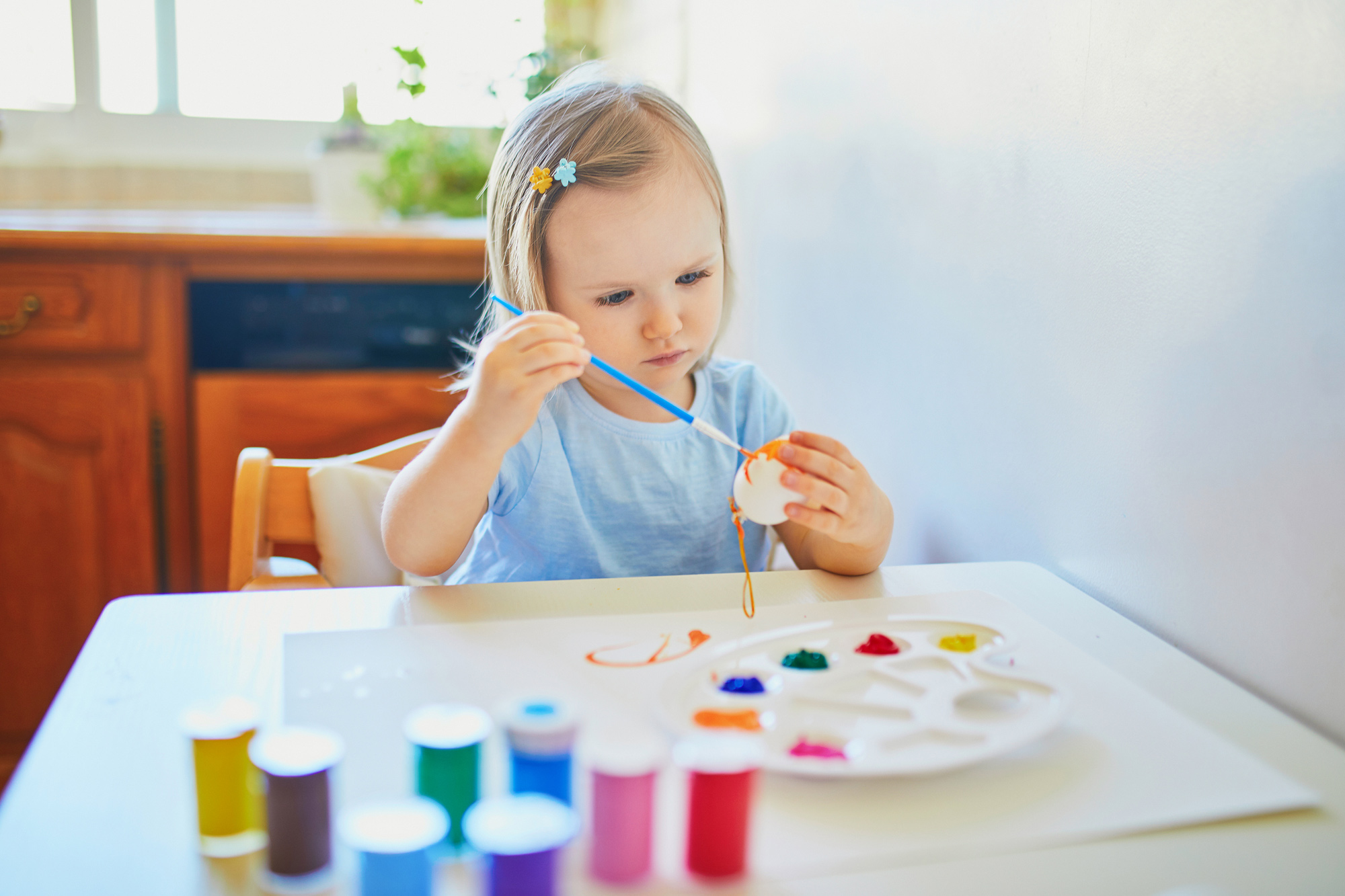 Niña pintando un huevo