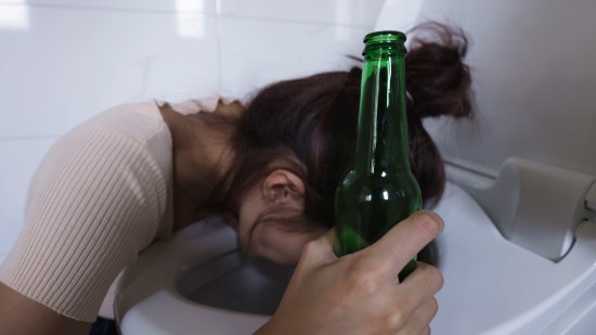 Chica vomitando a causa del alcohol