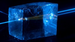 Un láser azul atravesando un cristal de calcita