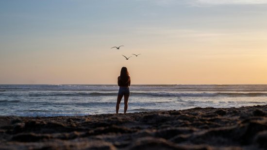 Hombre en un acantilado contemplando el mar