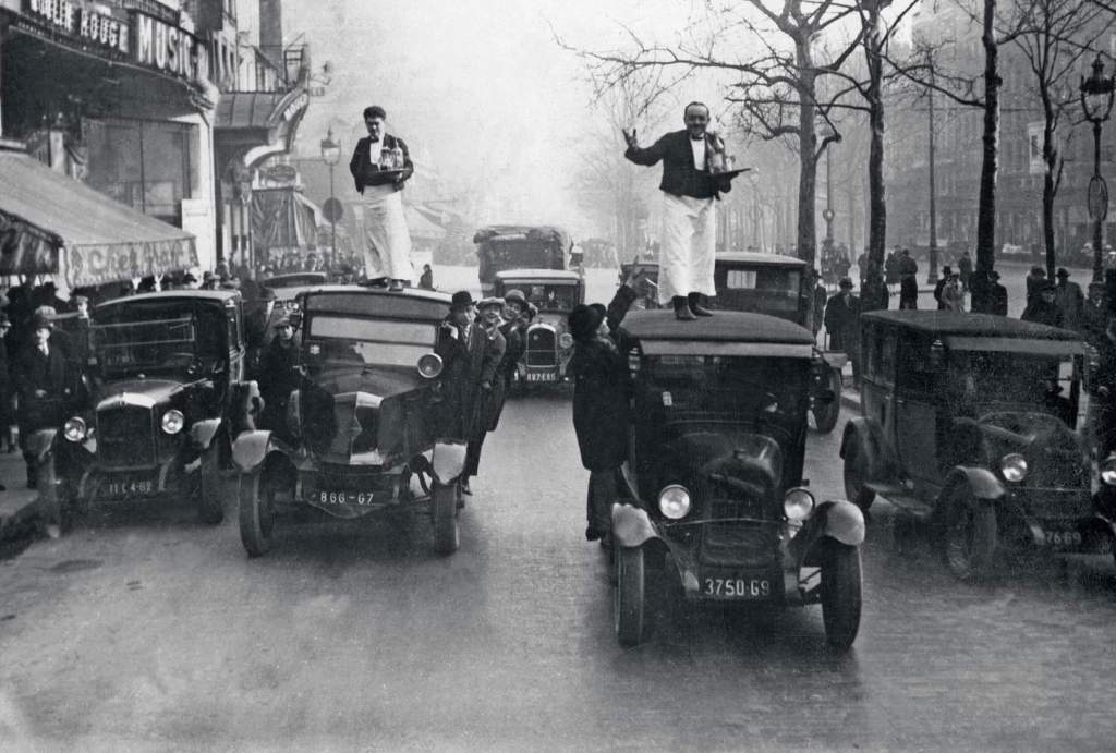 Carrera de camareros subidos a los techos de taxis en París