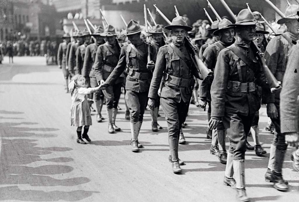 Un militar estadounidense saluda a una niña durante un desfile en Londres en 1917