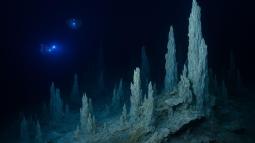 Representación fantasiosa inspirada en imágenes reales de la Ciudad Perdida: un paisaje submarino de torres minerales donde la vida prospera sin luz solar, a miles de metros de profundidad