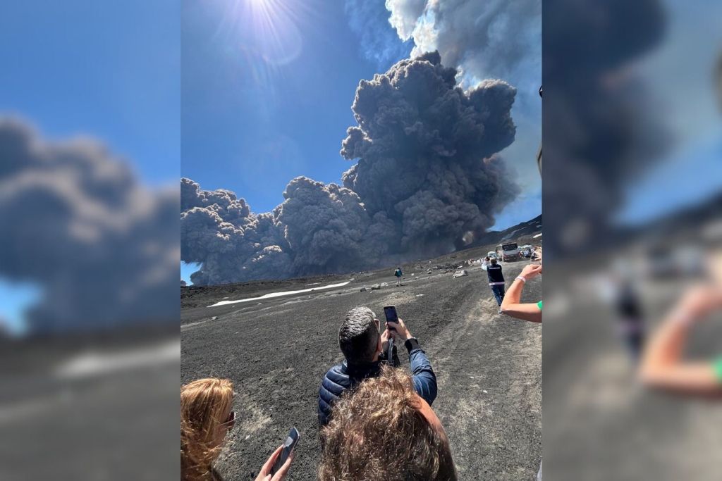 Turistas capturan el momento exacto en que una densa columna de ceniza se eleva desde el cráter del Etna, tiñendo el cielo siciliano