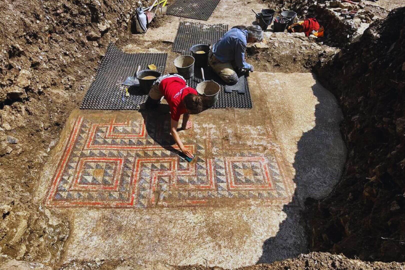 Los arqueólogos retiran con delicadeza la parte central del mosaico, decorada con un complejo diseño geométrico
