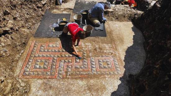 Los arqueólogos retiran con delicadeza la parte central del mosaico, decorada con un complejo diseño geométrico