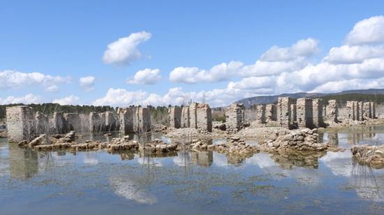 Figura 3. Ruinas del antiguo Real Sitio de La Isabela y ejemplos del deterioro por colapsos, depósitos de lodo, vegetación lacustre y eflorescencias, entre otros. Fuente: Proyecto DAMAGE (Análisis del Deterioro en Ambientes de Aguas Embalsadas del Patrimonio Cultural en Piedra. PID2019-109605RB-I00).