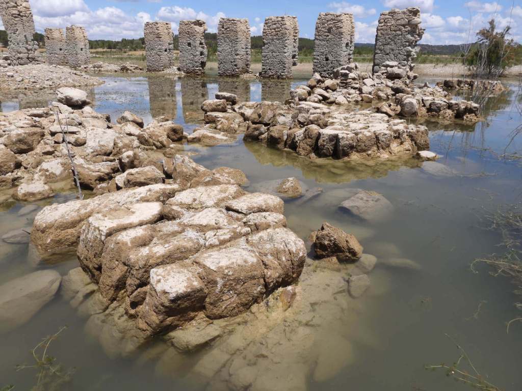 Figura 3. Ruinas del antiguo Real Sitio de La Isabela y ejemplos del deterioro por colapsos, depósitos de lodo, vegetación lacustre y eflorescencias, entre otros. Fuente: Proyecto DAMAGE (Análisis del Deterioro en Ambientes de Aguas Embalsadas del Patrimonio Cultural en Piedra. PID2019-109605RB-I00).
