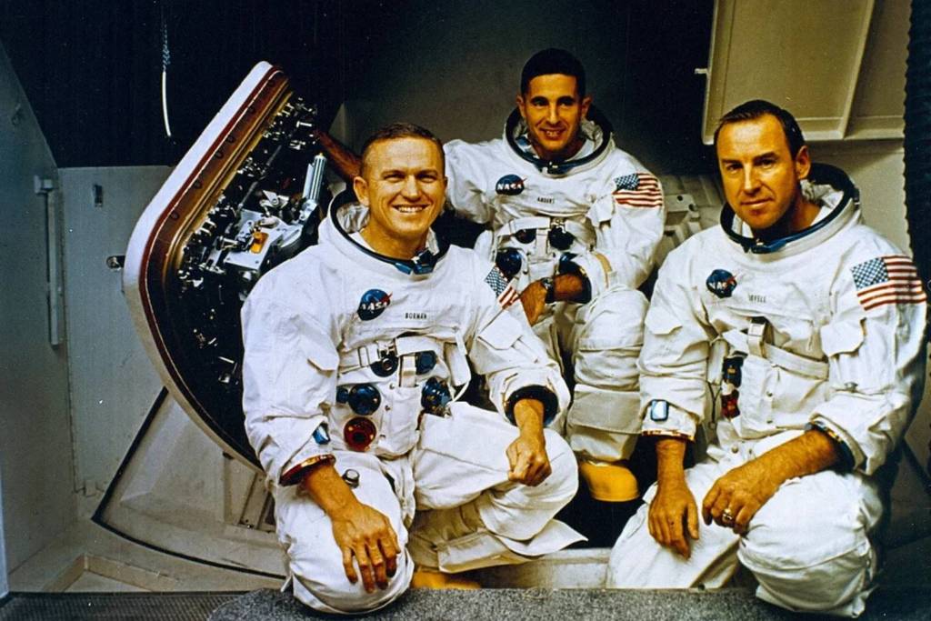 Los astronautas del Apolo 8, Frank Borman, William Anders y Jim Lovell, posan frente al simulador de la misión durante su entrenamiento
