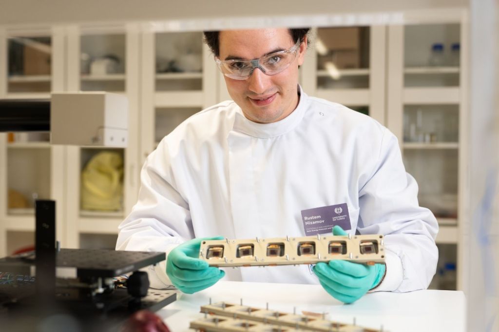 El investigador doctoral Rustem Nizamov, junto a las células solares sensibilizadas empleadas en el estudio