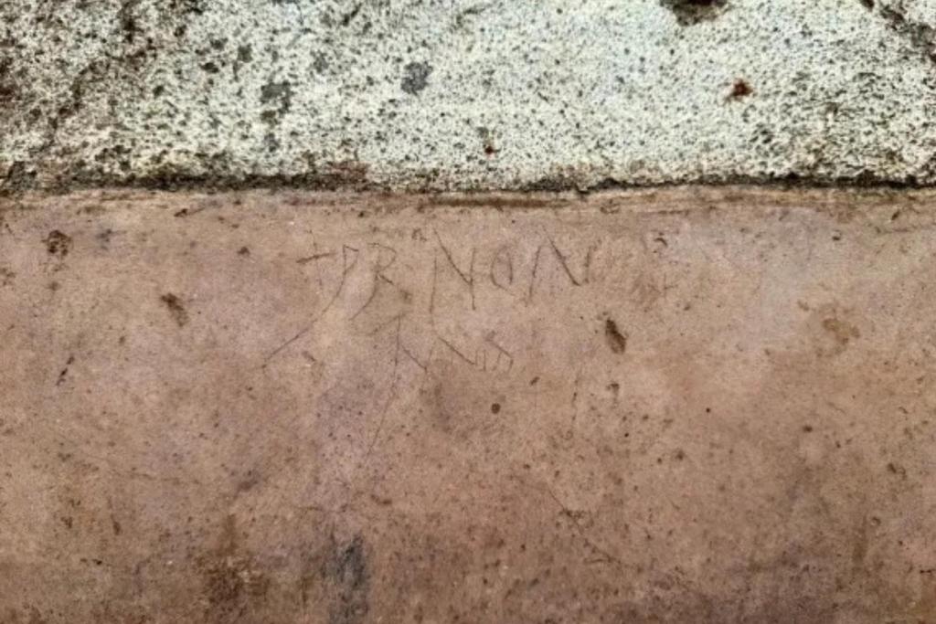 Probablemente, alguien grabó graffiti en la pared sobre el banco para matar el tiempo mientras esperaba