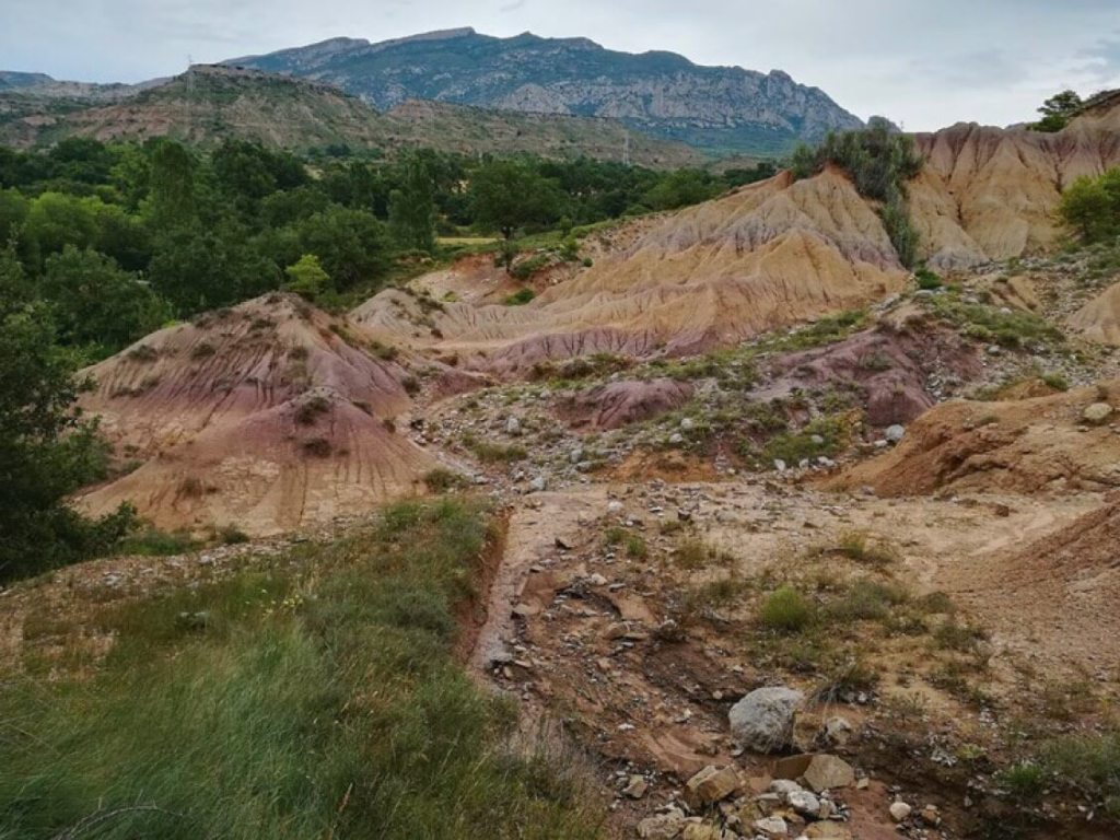 La fotografía de arriba es una vista de los espectaculares afloramientos de las rocas de finales del Cretácico Superior del Pirineo en Isona, en la provincia de Lleida (Cataluña), lugar en el que se encuentran una gran variedad de fósiles de dinosaurios.