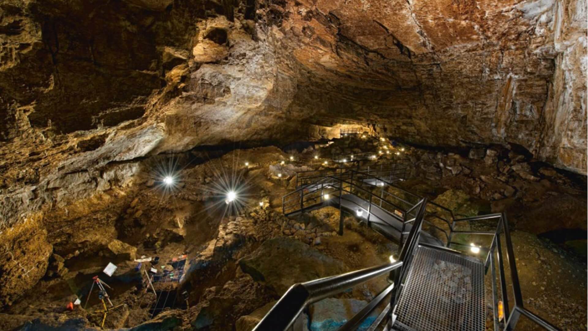 La primera sala de El Pendo sorprende por sus amplias dimensiones de 45 m de ancho por 22 m de altura. Al fondo, el friso con 19 de las 24 pinturas documentadas hasta la fecha; visible desde el espacio de ocupación, integra el arte a la vida cotidiana de las poblaciones que lo habitaron.